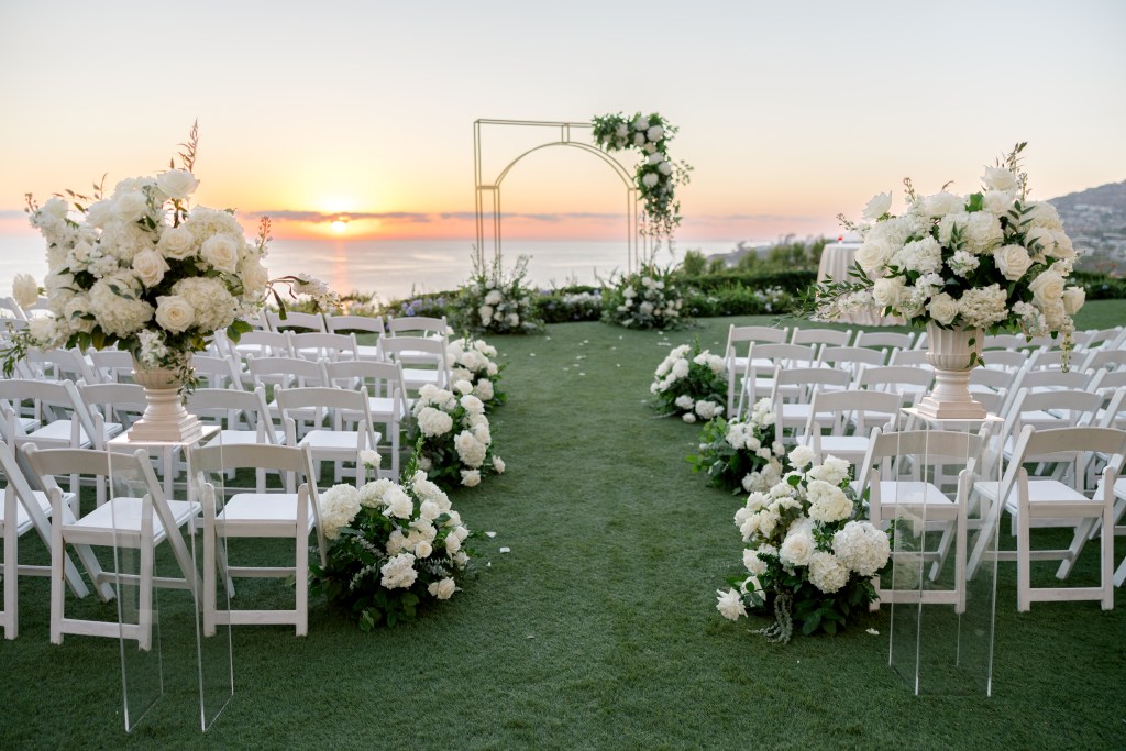 Outdoor California wedding ceremony with white floral arrangements